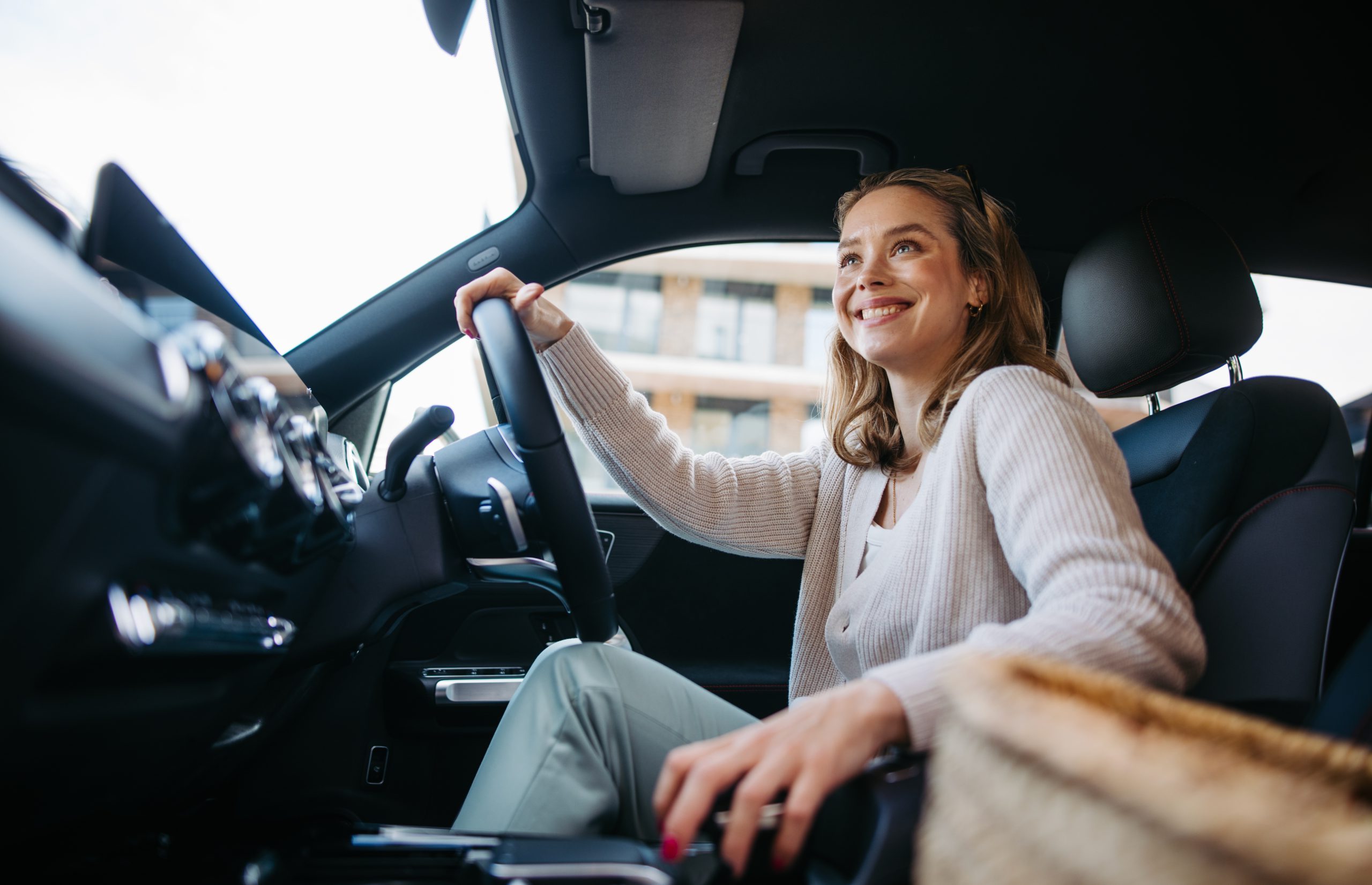 Happy Woman Driving Her New Electric Car.