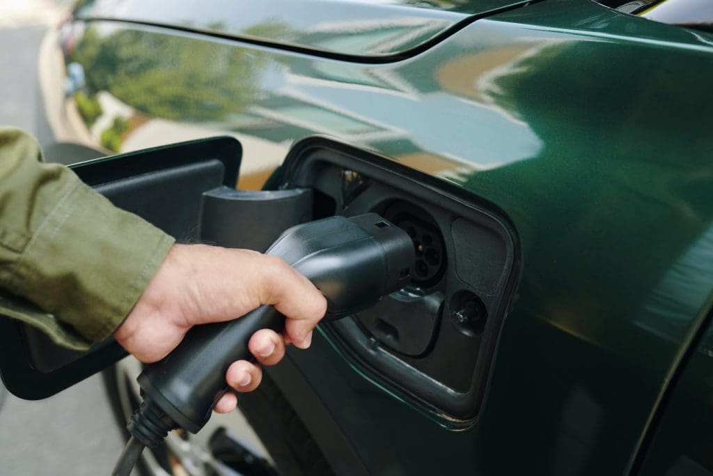 Man Inserting Plug Into Electric Car