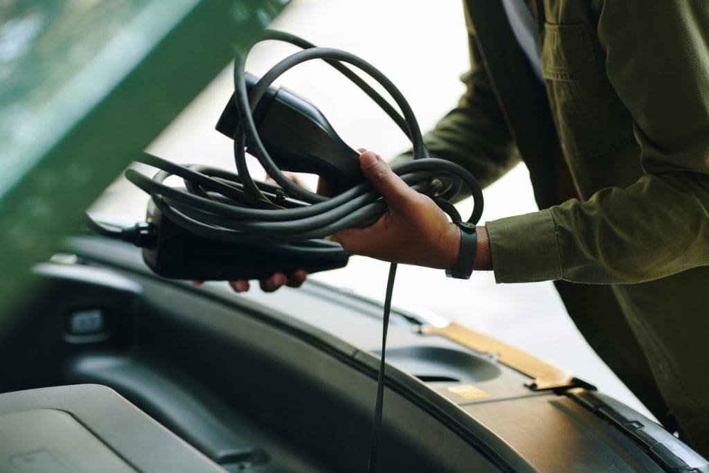 Driver Putting Charging Cable In Trunk